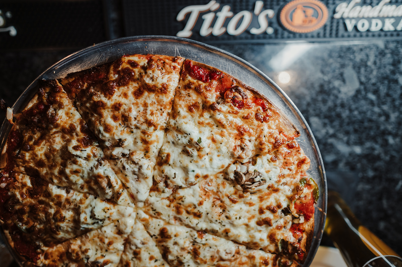 A pizza with cheese, mushrooms and green peppers sits on the bar at Riverside Sports Bar in Batavia Illinois.