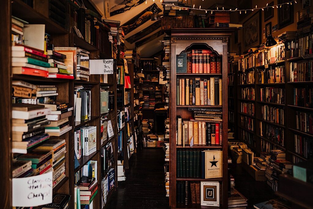 The inside of The Book Shop in Batavia Illinois.  The walls are lined with second hand books and there are piles of books all over the store. 