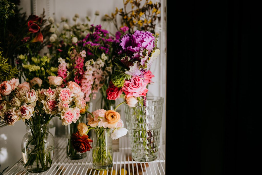 Wedding and home flower arrangements sit in a fridge ready for their new homes from Farmdog Flowers in Batavia Illinois. 