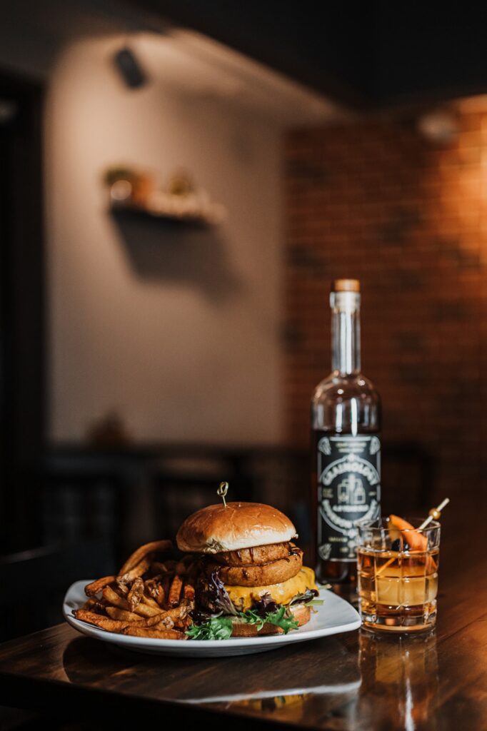A burger with onion rings sits on a table at Windmill Grille in Batavia Illinois. 